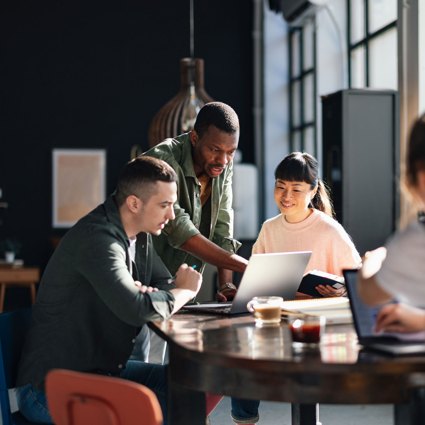 Group of employees looking at laptop screen