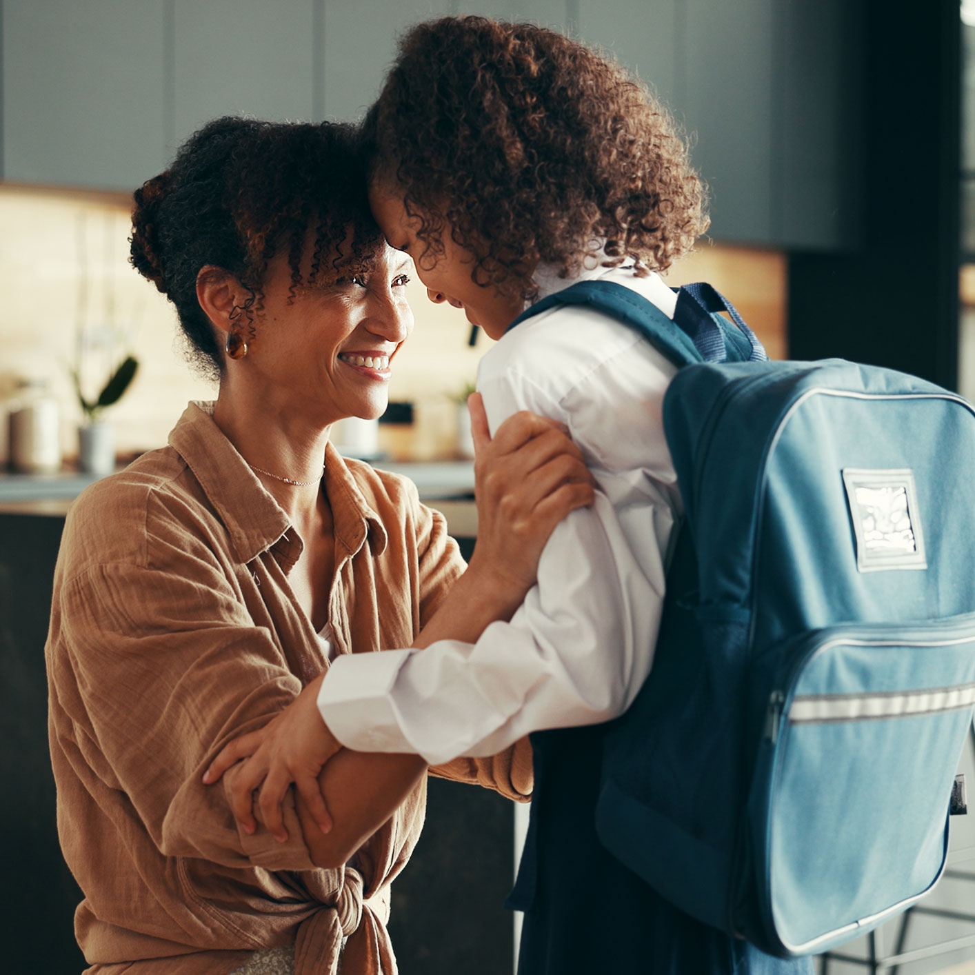 Mother and daughter getting ready before school smiling at each other