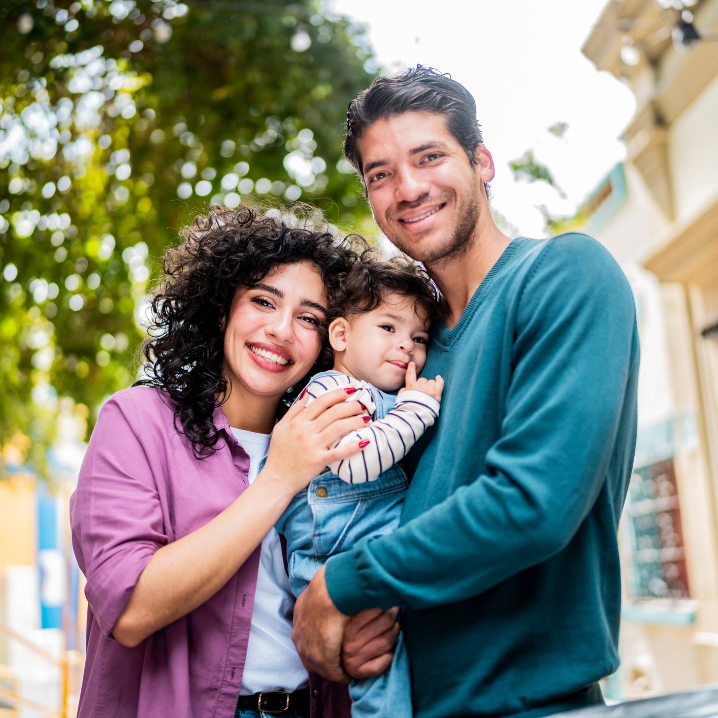 Latin couple holding their  baby boy smiling